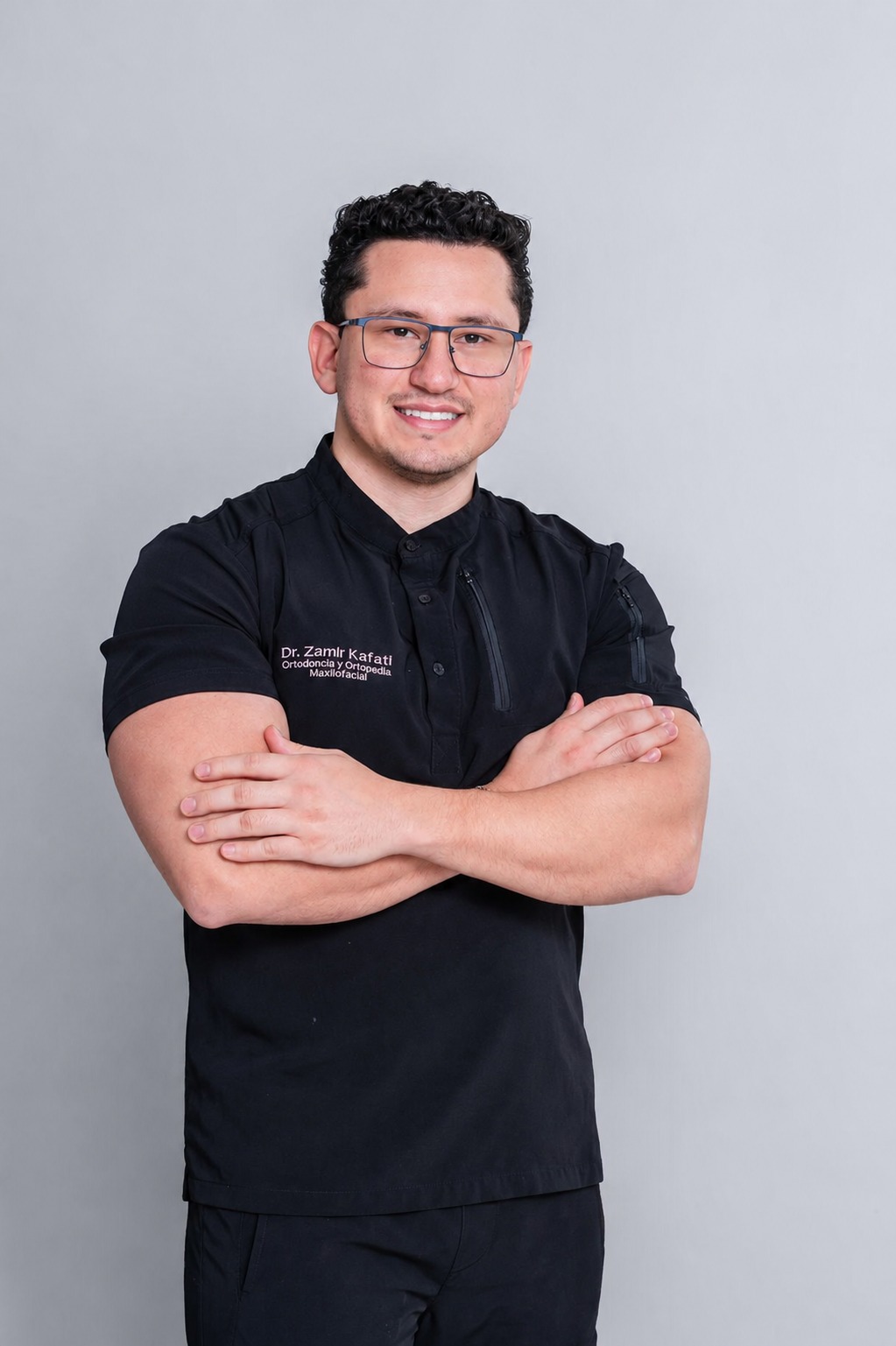 Dr. Zamir Kafati, ortodoncista, con uniforme negro y brazos cruzados